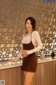 A woman standing in front of a counter holding a cup of coffee.