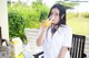 A woman sitting at a table drinking orange juice.