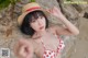 A woman in a red and white bikini and a straw hat.