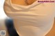 A close up of a woman wearing a white top.