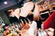 A woman in lingerie leaning over a bar counter.