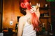 A woman with red hair standing in a kitchen.