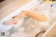 A woman laying in a bathtub filled with foam.