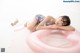 A woman laying on top of a pink inflatable ring.