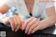 A woman sitting at a table with her hands on the table.